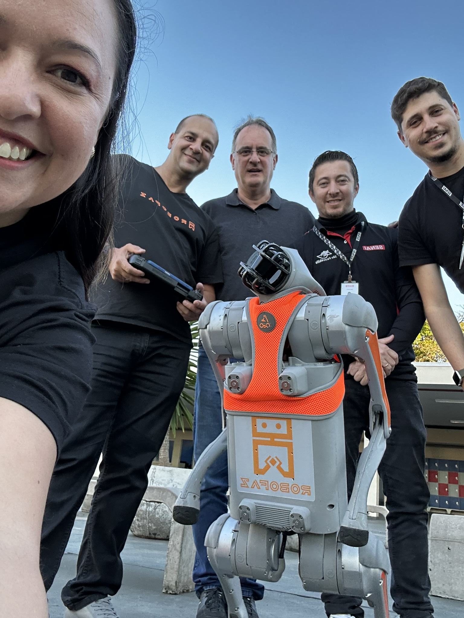 Equipe da RoboFaz com o cão robô Roby em visita ao SENAI
